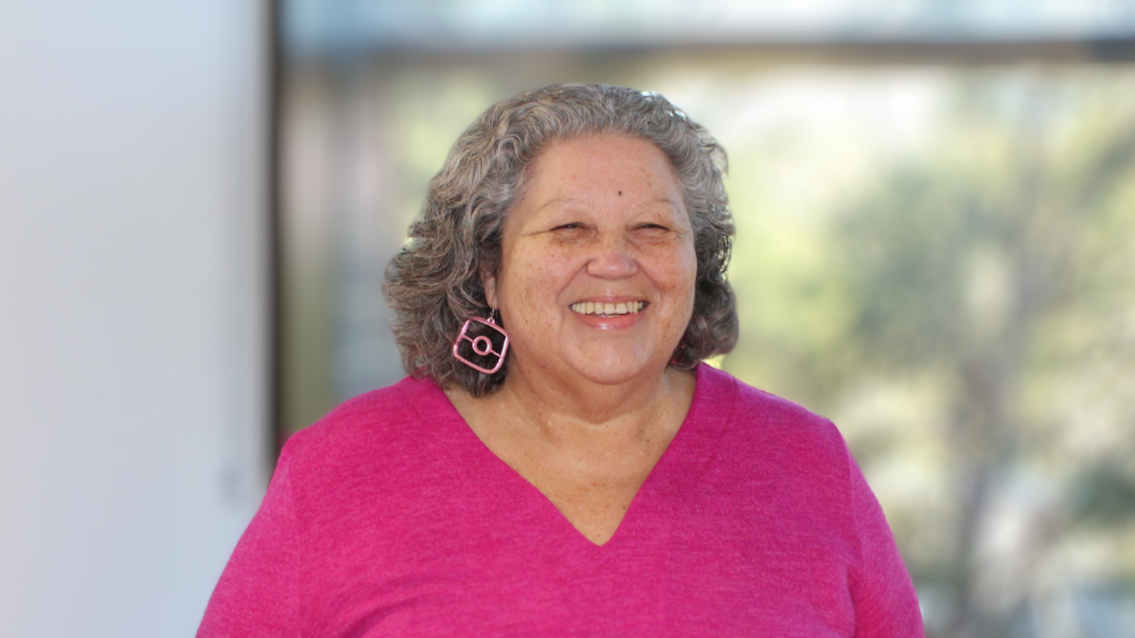 Professor of Critical Indigenous Studies at Macquarie University, Dr Bronwyn Carlson, a smiling woman in a bright pink top