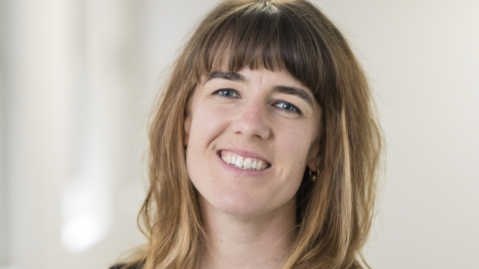 Dr Van Toorn, a smiling person in a black shirt