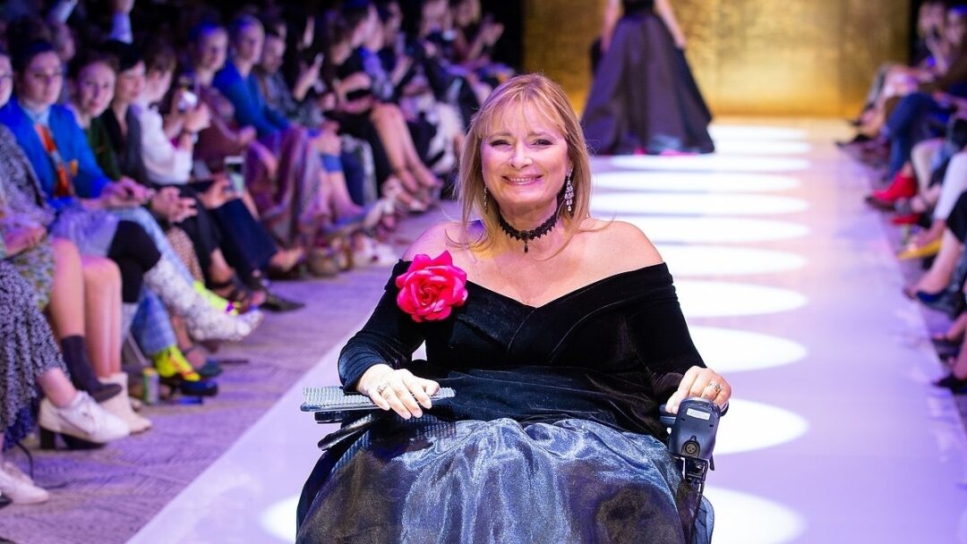 Carol Taylor in a power chair on a fashion runway.