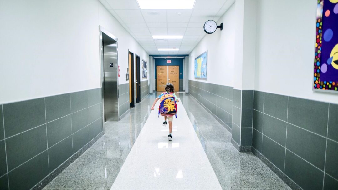 A child running down a school hallway