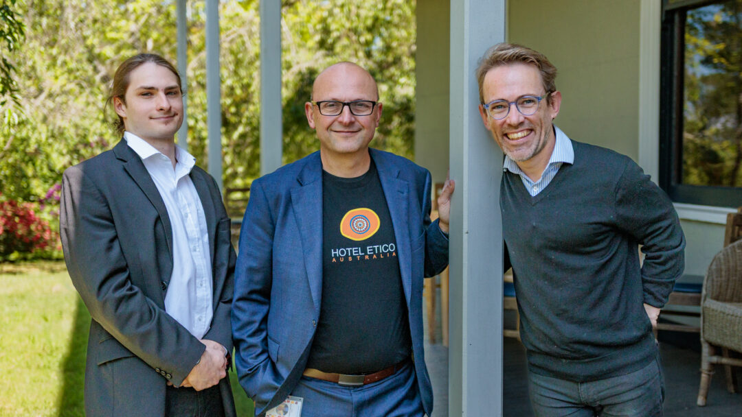 Quinn Jones and Andrea Comastri from Hotel Etico stand on a porch with Sam Drummond
