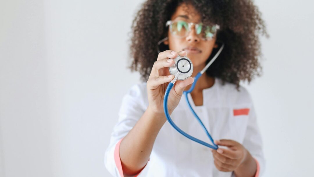 A person holding a stethoscope at the camera