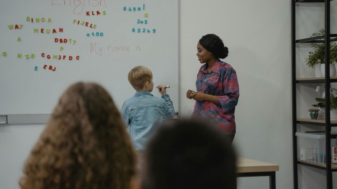 A teacher and student standing at a whiteboard