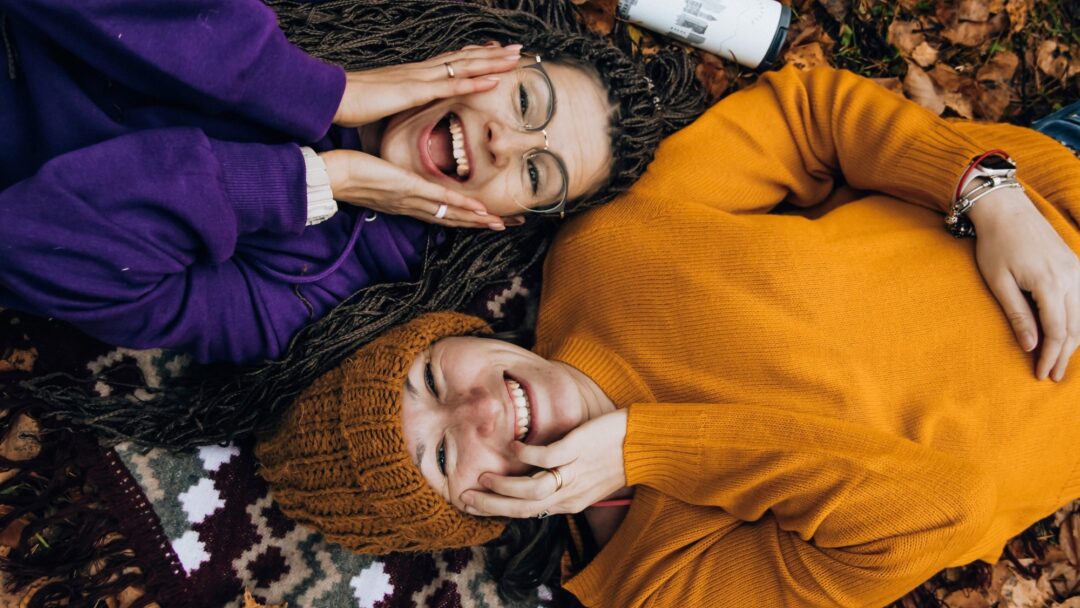 Two friends laying on the ground next to each other