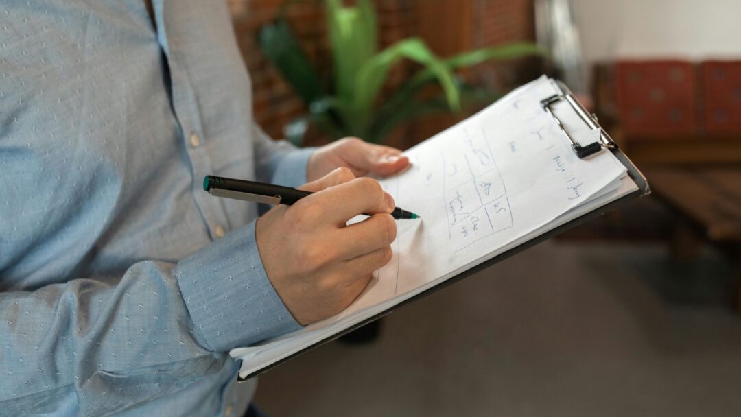 A man in a dress shirt holding a clipboard and pen
