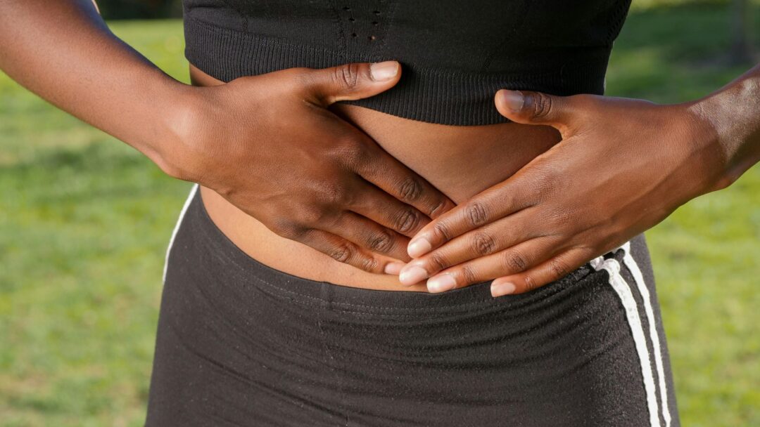 A person with their hands on their abdomen.