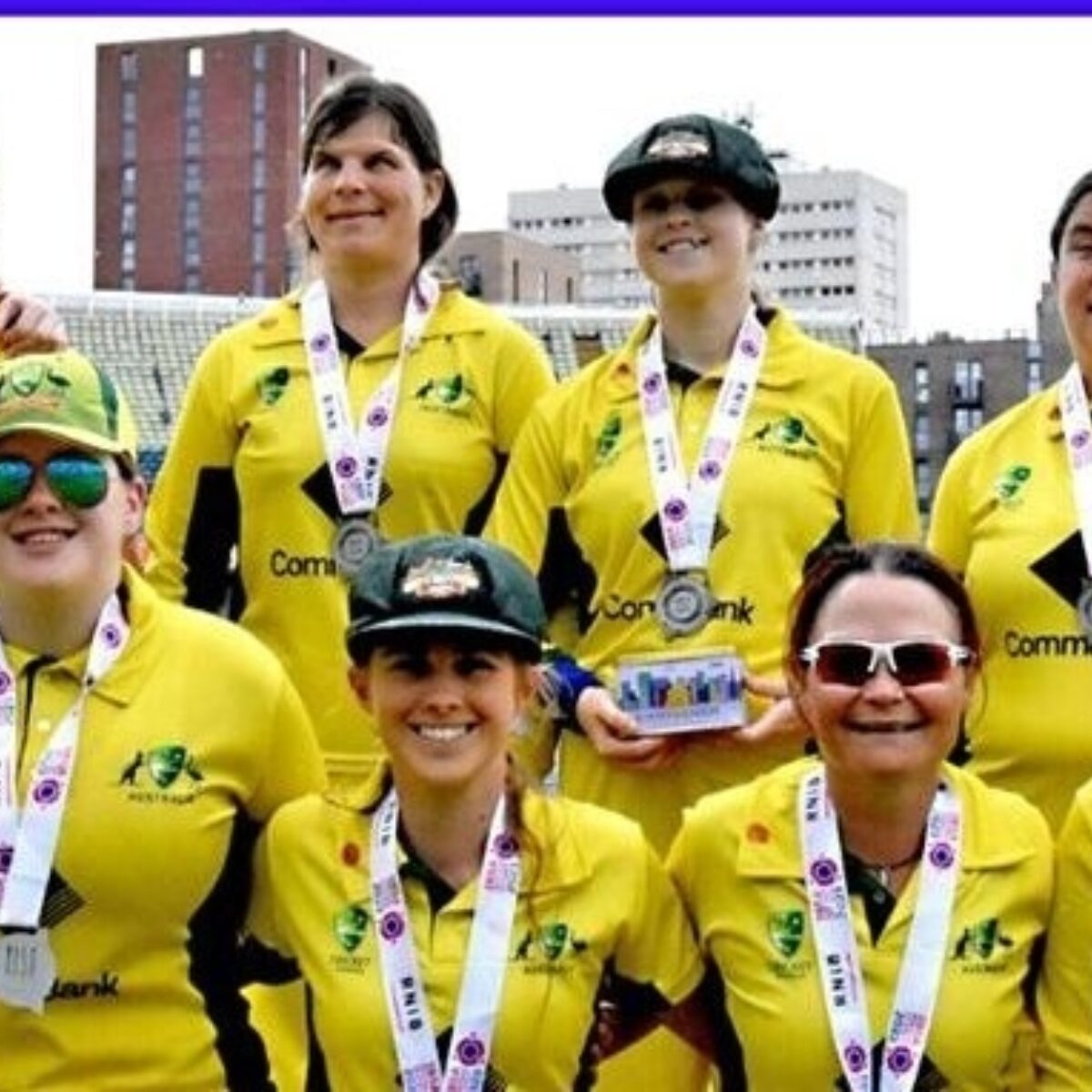 Some members of the Australian Blind Women's Cricket team, 2024 - standing together on a sports oval, wearing uniforms and medals.