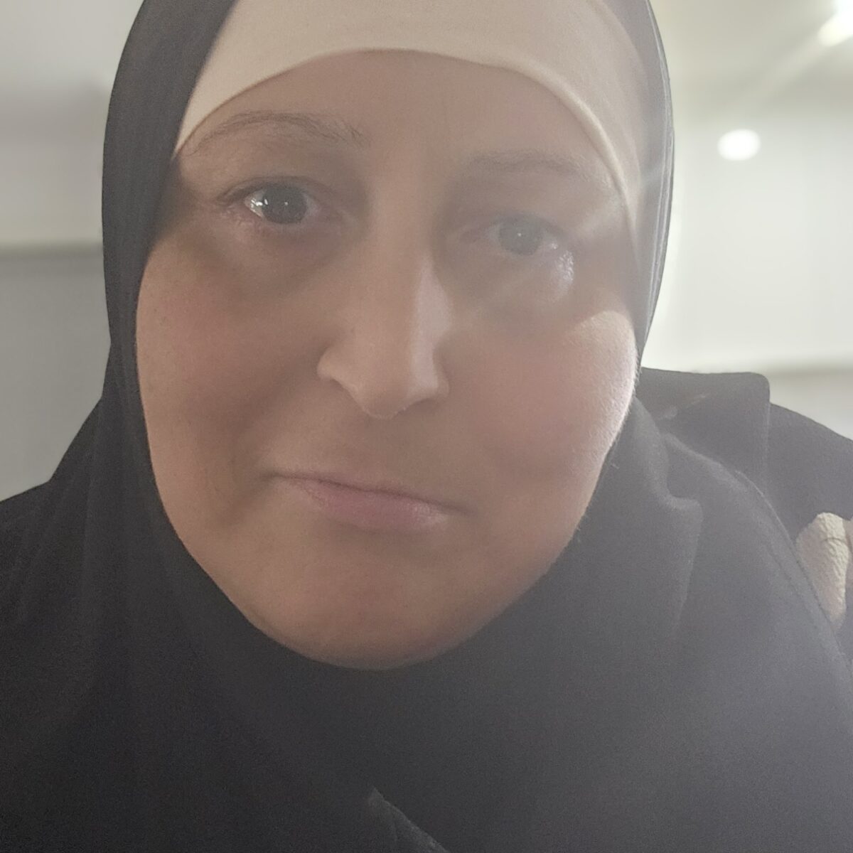 A headshot of Hala Baksmaty, a woman in black clothing