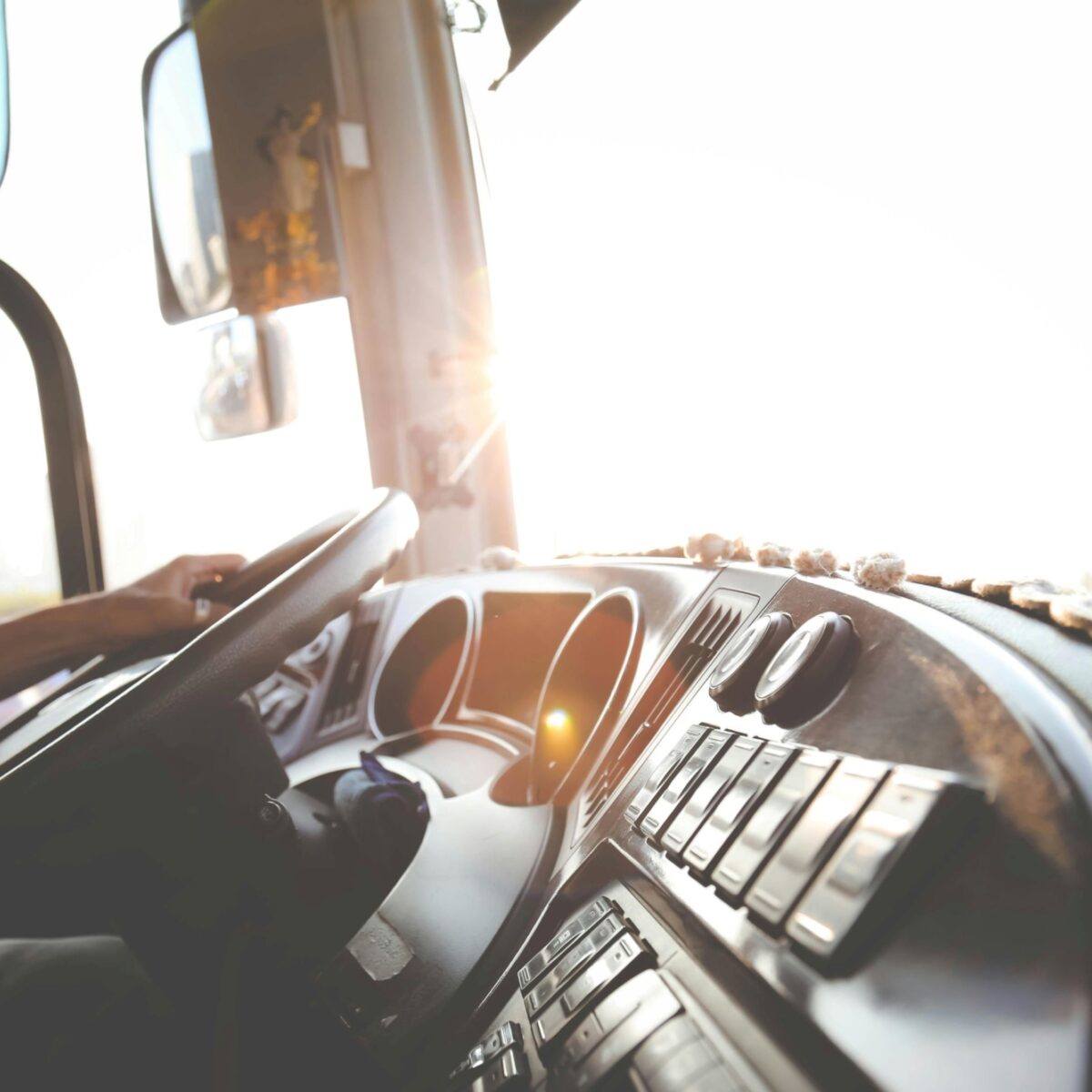A photo of the interior of a bus, with light obscuring the view through the windshield.