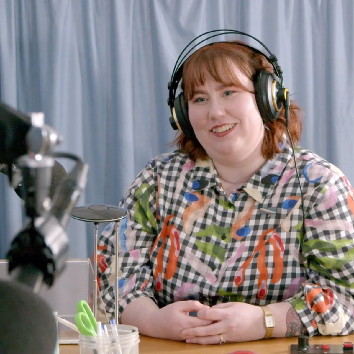 A photo of Rosie, a white woman, smiling at the recording desk.