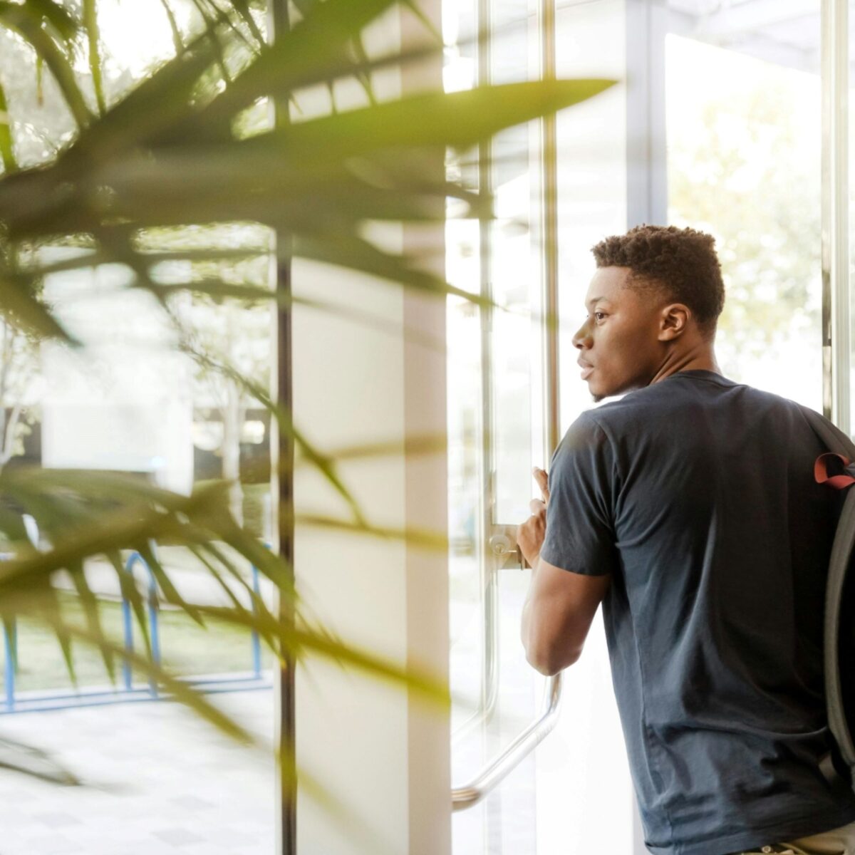 A person with a backpack exiting a building