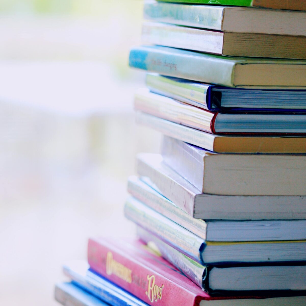 A stack of books with their different coloured spines showing.